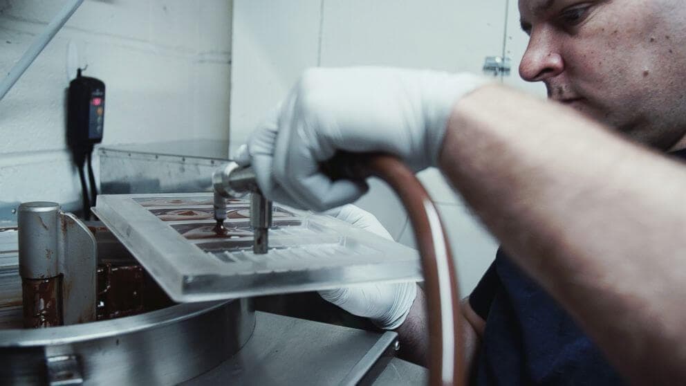 O chocolateiro premiado que trabalha em uma pequena oficina com máquinas improvisadas